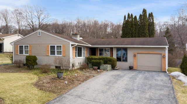 single story home featuring a front lawn, an attached garage, a chimney, and driveway