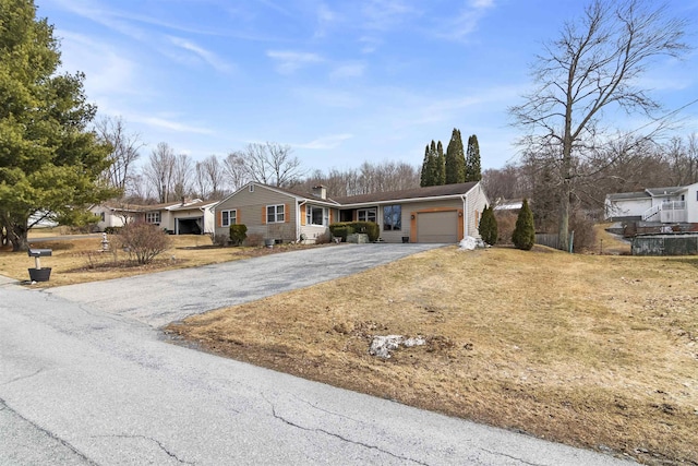 ranch-style house with aphalt driveway and a garage