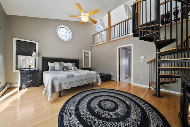 bedroom featuring baseboards, a high ceiling, and wood finished floors