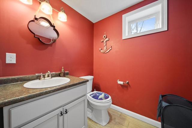 bathroom featuring vanity, toilet, and baseboards