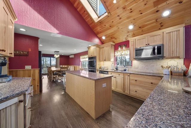 kitchen with stainless steel microwave, vaulted ceiling with skylight, light brown cabinets, and black electric cooktop