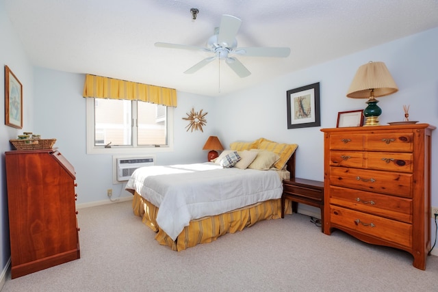 bedroom with a wall unit AC, carpet, baseboards, and ceiling fan