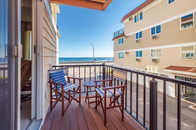 balcony featuring a water view and a beach view