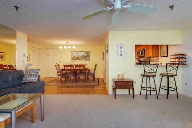 carpeted living room with baseboards and a textured ceiling