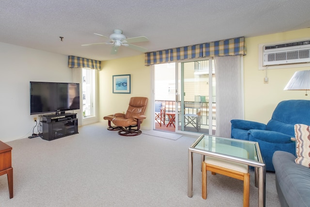 carpeted living area featuring a wall unit AC, a ceiling fan, and a textured ceiling