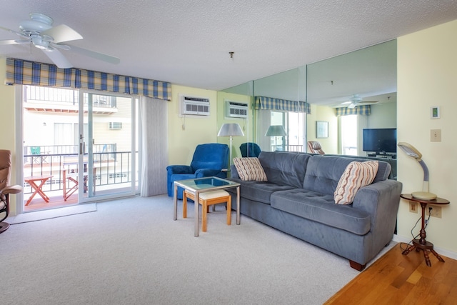 carpeted living room featuring baseboards, a wall mounted air conditioner, a textured ceiling, and ceiling fan