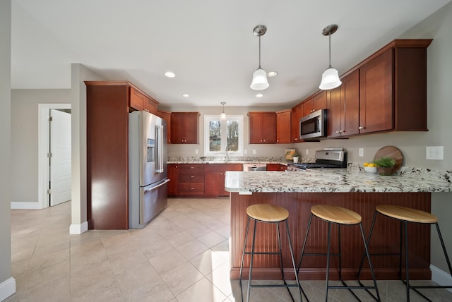 kitchen featuring decorative light fixtures, recessed lighting, appliances with stainless steel finishes, a peninsula, and baseboards