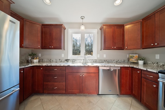 kitchen with light stone countertops, recessed lighting, a sink, appliances with stainless steel finishes, and pendant lighting