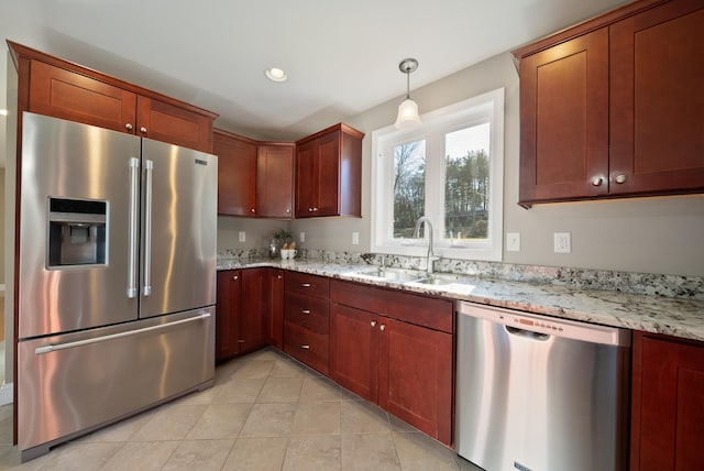 kitchen with light stone counters, appliances with stainless steel finishes, light tile patterned flooring, and a sink