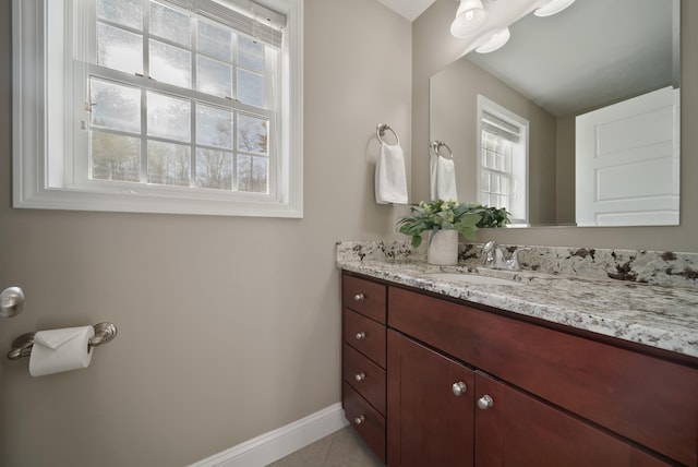 bathroom with tile patterned flooring, vanity, and baseboards