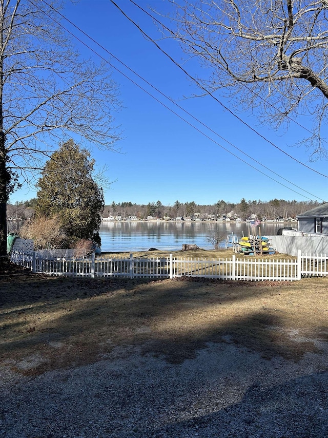 view of yard featuring a water view and fence