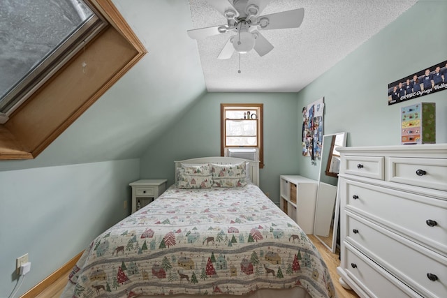 bedroom with light wood-style floors, lofted ceiling, a textured ceiling, and ceiling fan