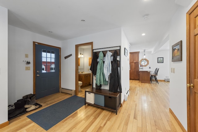 entrance foyer with light wood-type flooring, a baseboard heating unit, and baseboards