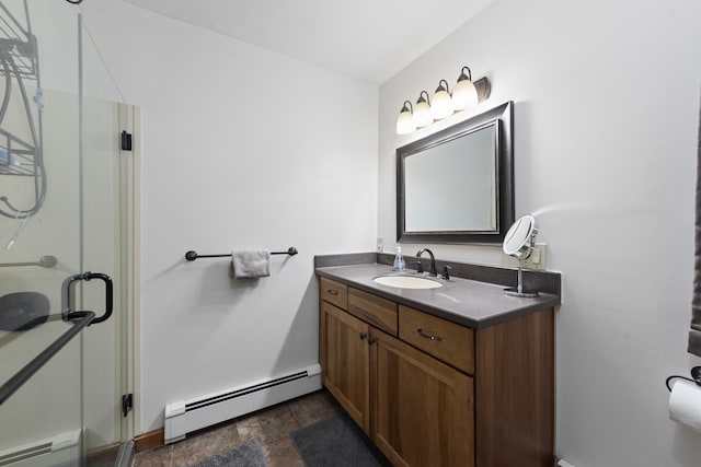 bathroom featuring baseboard heating, a shower stall, vanity, and stone finish floor