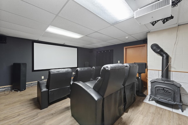 cinema room featuring concrete block wall, light wood-type flooring, and a drop ceiling