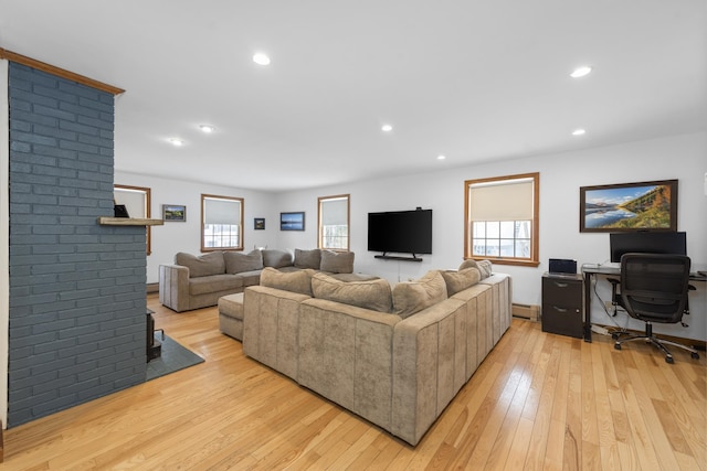 living room with a wealth of natural light, light wood-style flooring, and recessed lighting