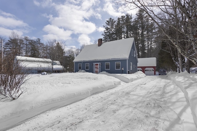 view of front of property with a garage, an outdoor structure, and a chimney