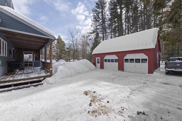 snow covered garage with a detached garage