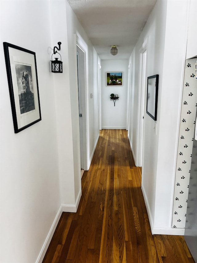 hall with dark wood-style floors and baseboards