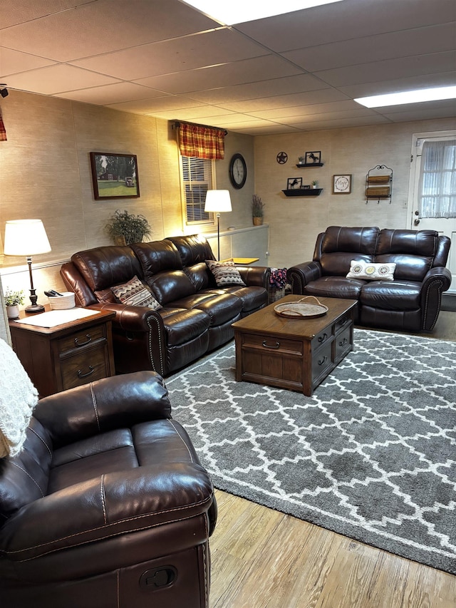 living area with wood finished floors and a drop ceiling