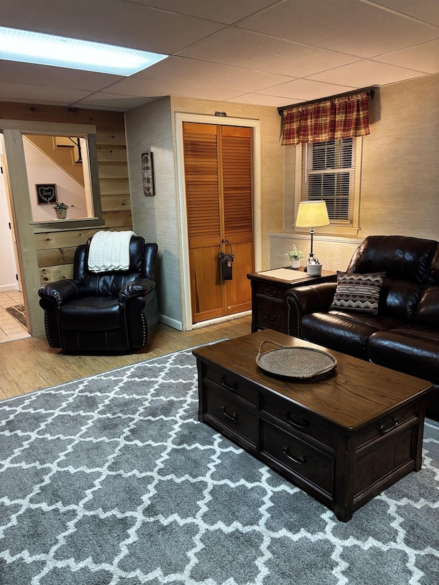 living area featuring wood finished floors and a paneled ceiling