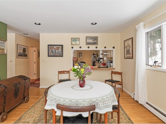 dining space with recessed lighting, light wood-style floors, baseboards, and a baseboard radiator