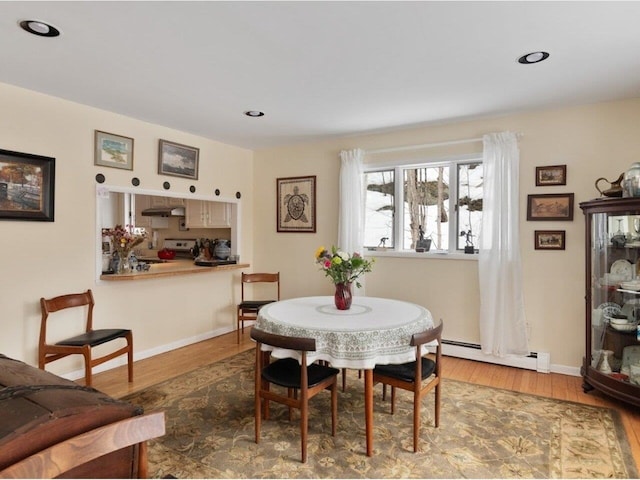 dining space featuring recessed lighting, wood finished floors, baseboards, and a baseboard radiator