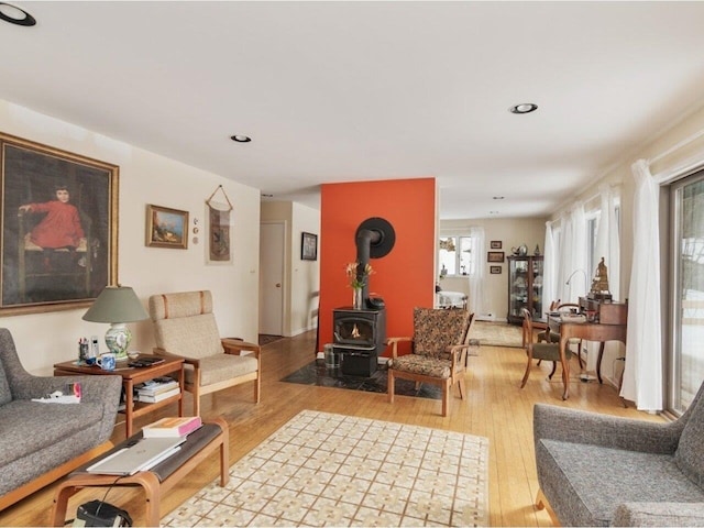 living area with a wood stove, recessed lighting, and light wood-style floors