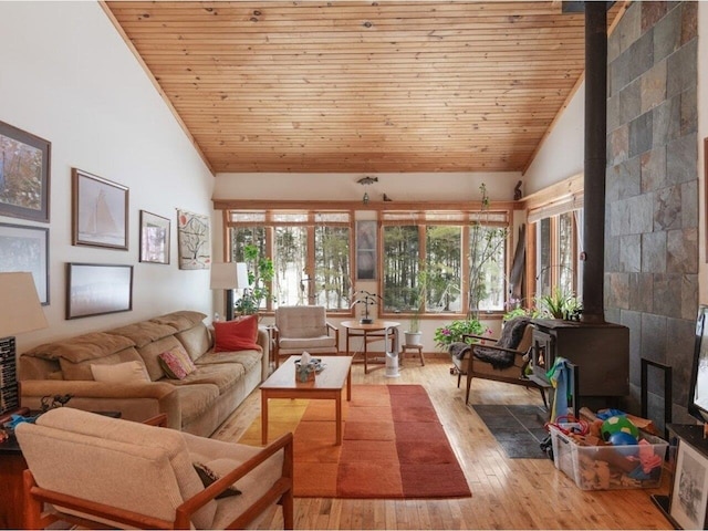 living room with a wood stove, wood ceiling, wood-type flooring, and high vaulted ceiling