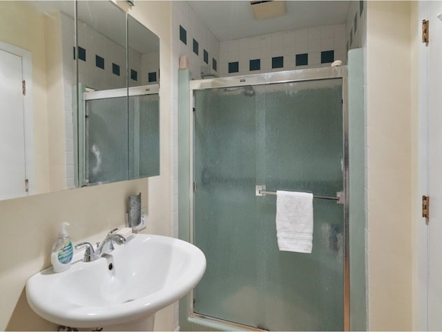 full bathroom with a stall shower and a sink