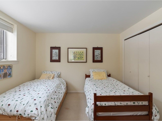 bedroom featuring a closet, carpet floors, and baseboards