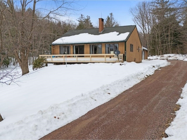 view of front facade featuring a chimney and a wooden deck