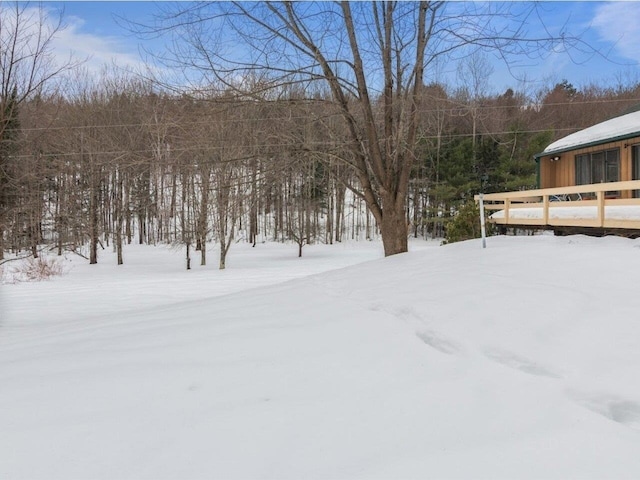 snowy yard featuring a wooden deck