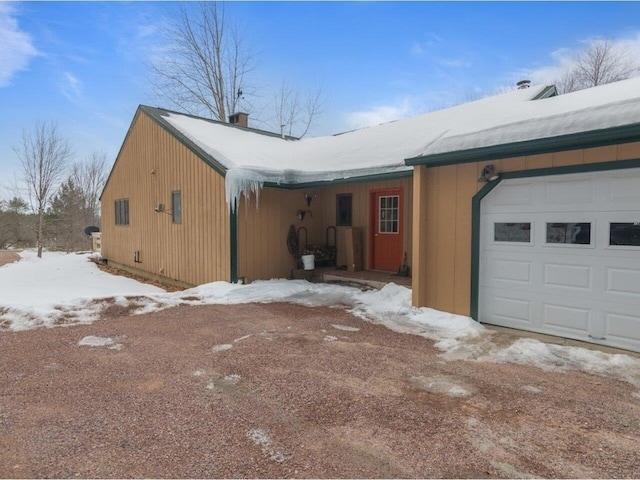 view of snowy exterior with a garage