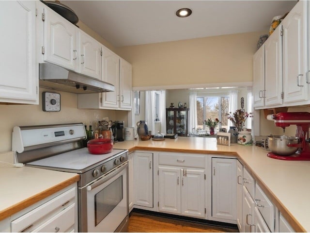 kitchen featuring white electric range, under cabinet range hood, light countertops, and white cabinetry