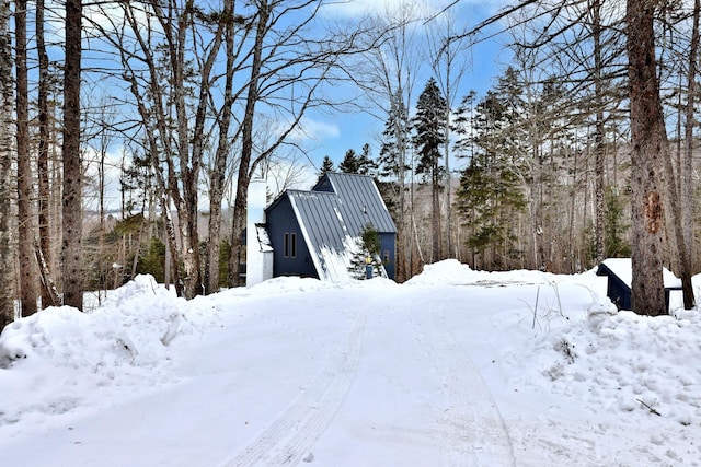 snow covered property with a standing seam roof and metal roof