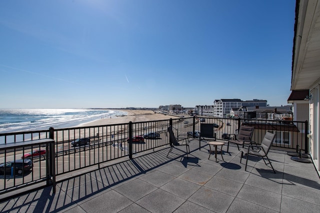 view of patio / terrace featuring a view of the beach and a balcony