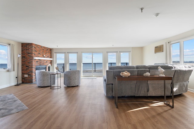 living area with a fireplace, wood finished floors, baseboards, and a wealth of natural light