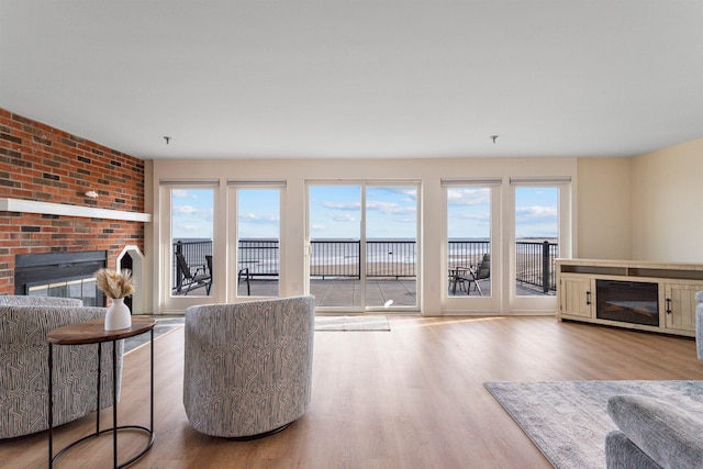 living room with a brick fireplace and wood finished floors