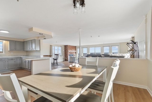 dining space featuring baseboards and light wood-style flooring