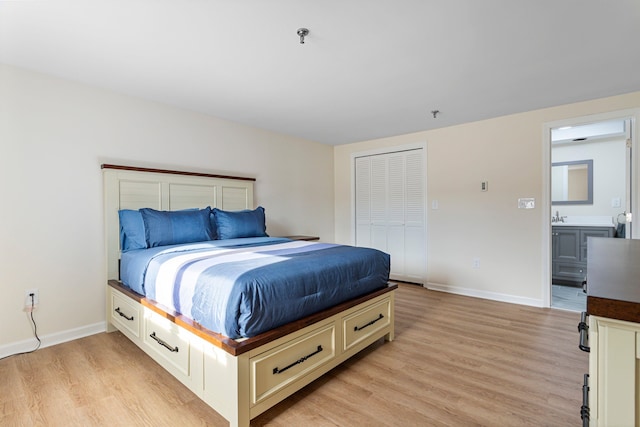 bedroom featuring light wood-style flooring, baseboards, a closet, and a sink