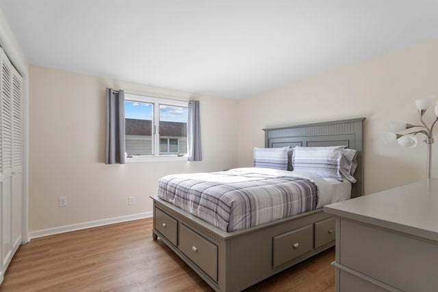 bedroom featuring a closet, baseboards, and light wood finished floors