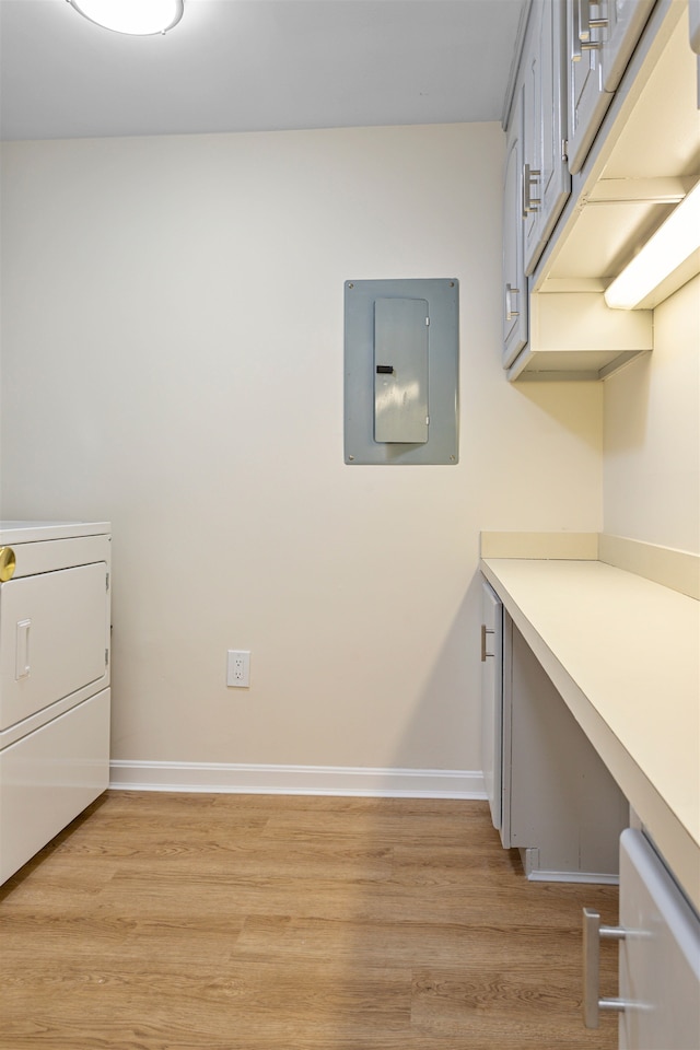 laundry area featuring baseboards, electric panel, laundry area, washer / dryer, and light wood-style flooring