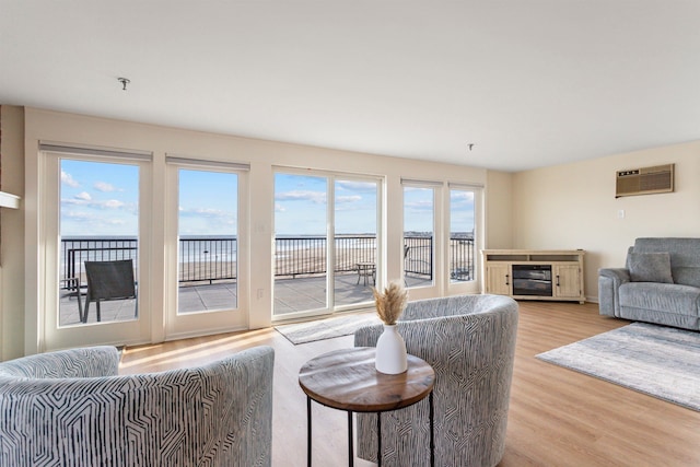 living room with light wood-style flooring and a wall mounted air conditioner