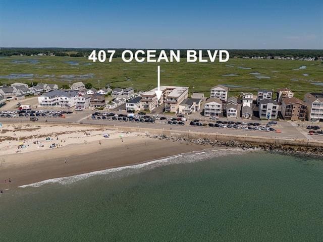 birds eye view of property featuring a view of the beach and a water view