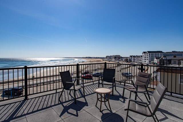 balcony with a water view and a view of the beach