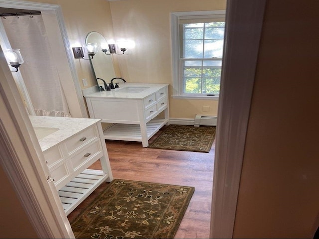 full bathroom featuring vanity, wood finished floors, baseboards, and baseboard heating