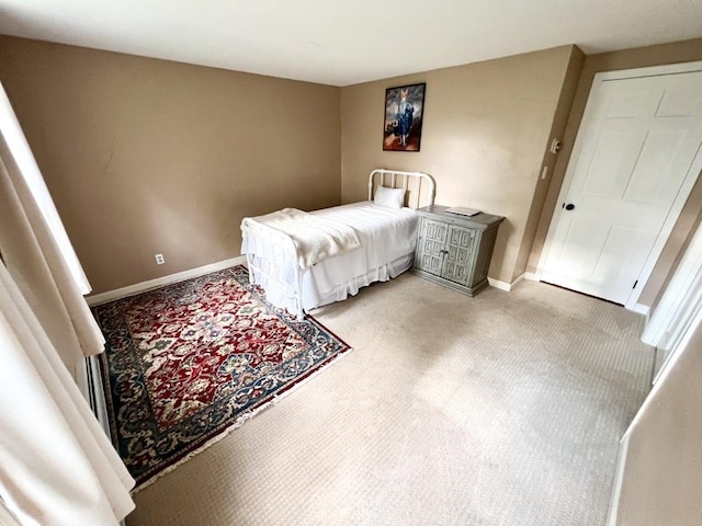 bedroom with baseboards and light carpet