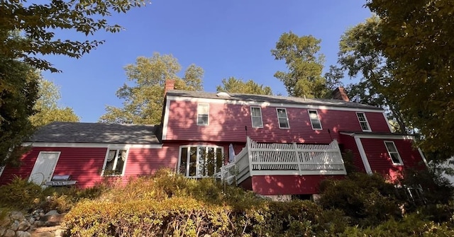 back of house featuring a chimney