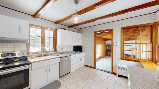 kitchen featuring radiator, a sink, stainless steel appliances, light countertops, and wall chimney range hood